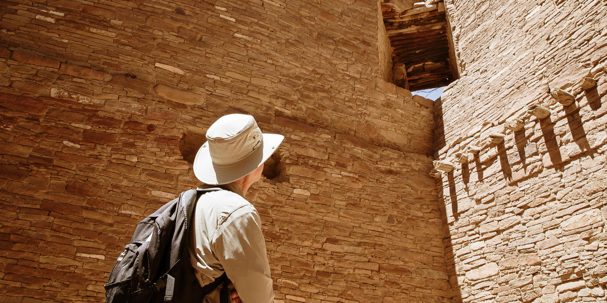 Person looking up inside walls of a building in Chaco Canyon