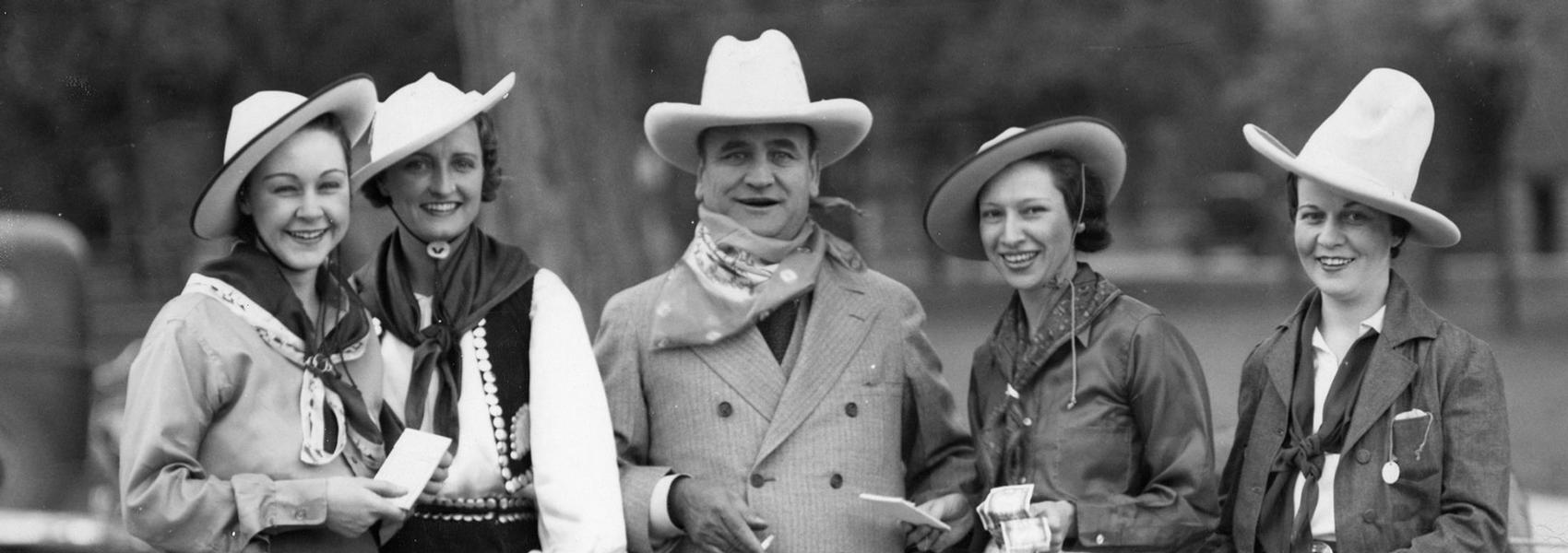 Clyde wearing Cowboy hat in center two women in Cowboy hats to his left and right