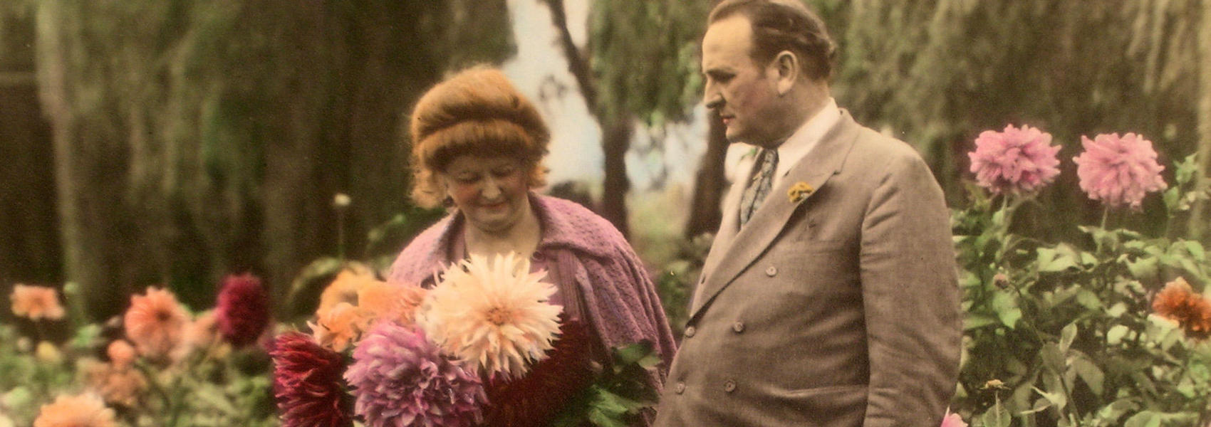 Color phot of Clyde and Carrie Tingley in garden, Carrie holding flowers