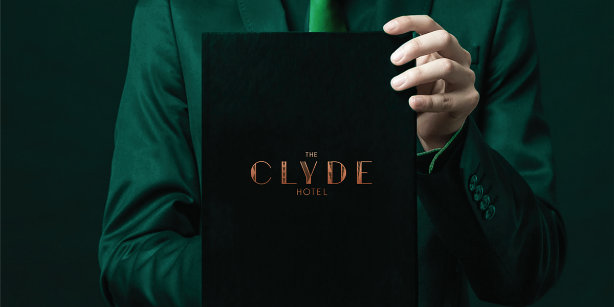 Man holding black menu with Clyde logo on it