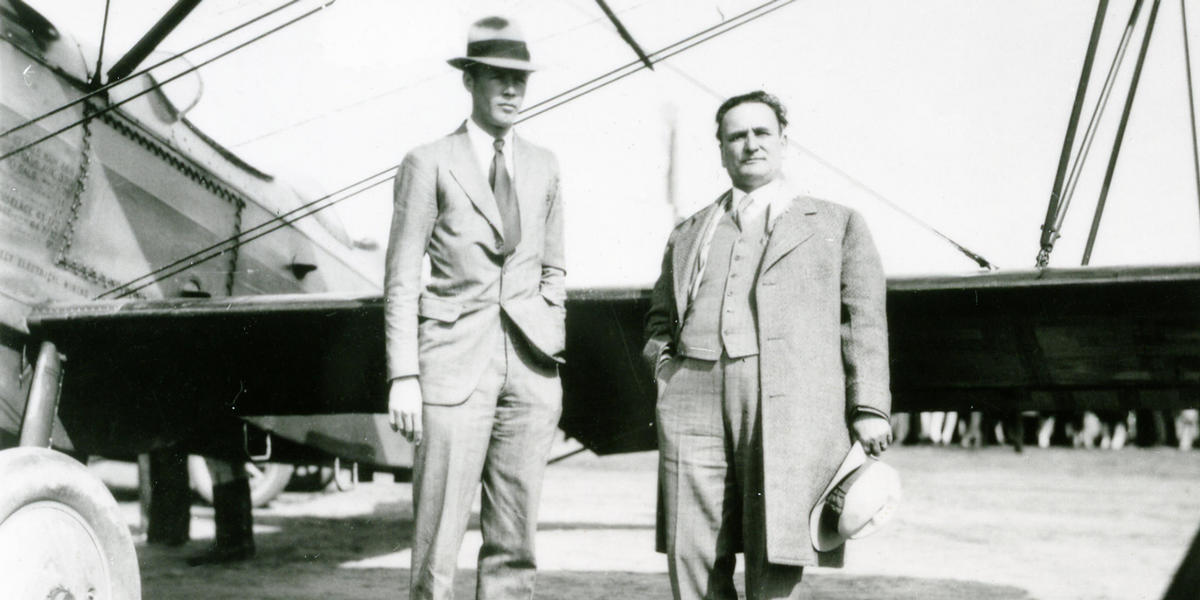 Clyde posing with another gentleman in front of plane