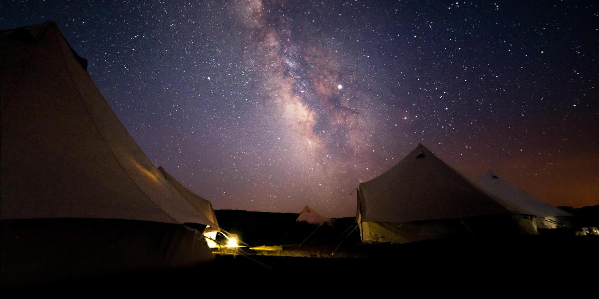 Tents set up in with starry night sky in background